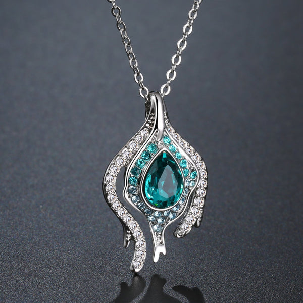 KHAISTA blue crystal pendant chain necklace on white background