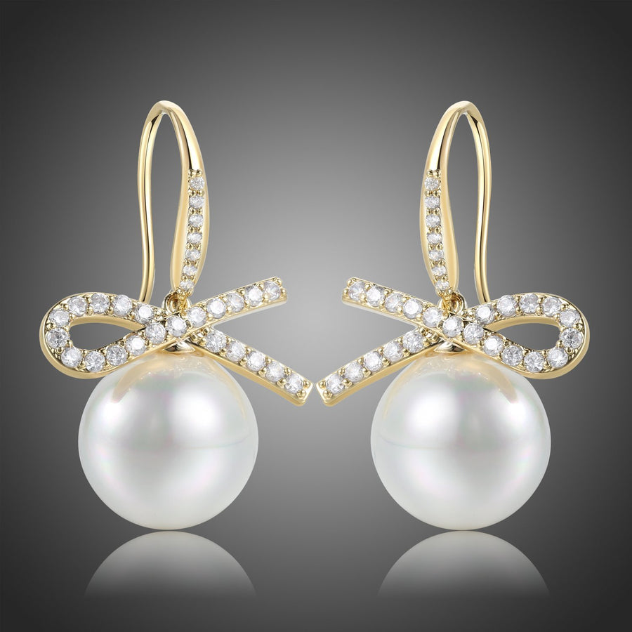 KHAISTA pearl bow knot dangle drop earrings on white background