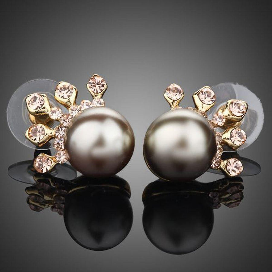 KHAISTA chocolate pearl crown stud earrings on white background
