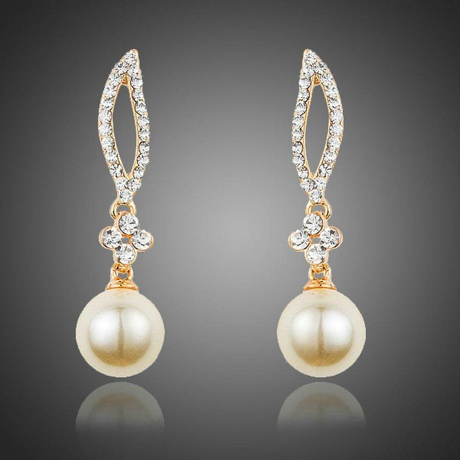 KHAISTA crystal leaf pearl drop earrings on white background