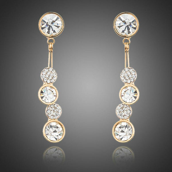 KHAISTA dangling crystal drop earrings on white background