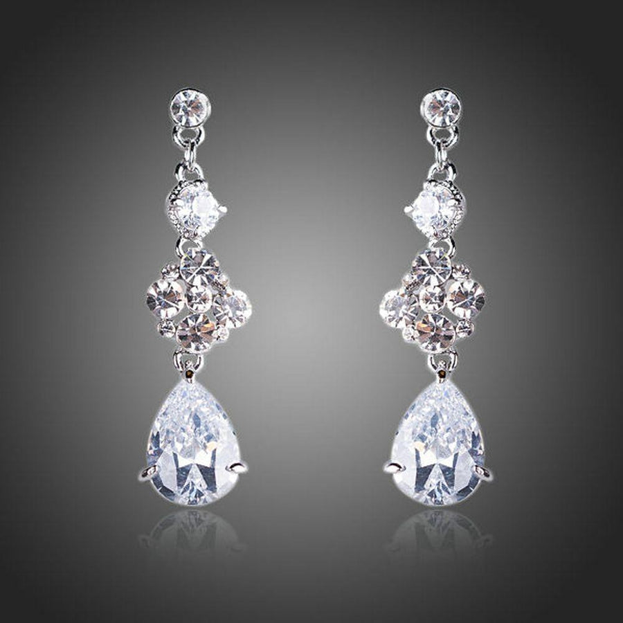 KHAISTA flower design CZ drop earrings on white background