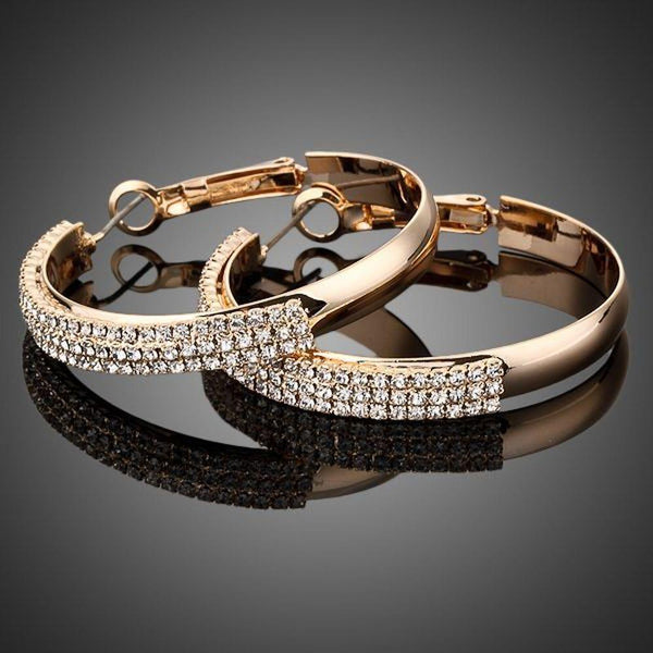 KHAISTA gold plated bangle design drop earrings on white background