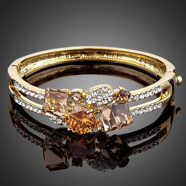 KHAISTA gold plated caramel crystal bangle on white background