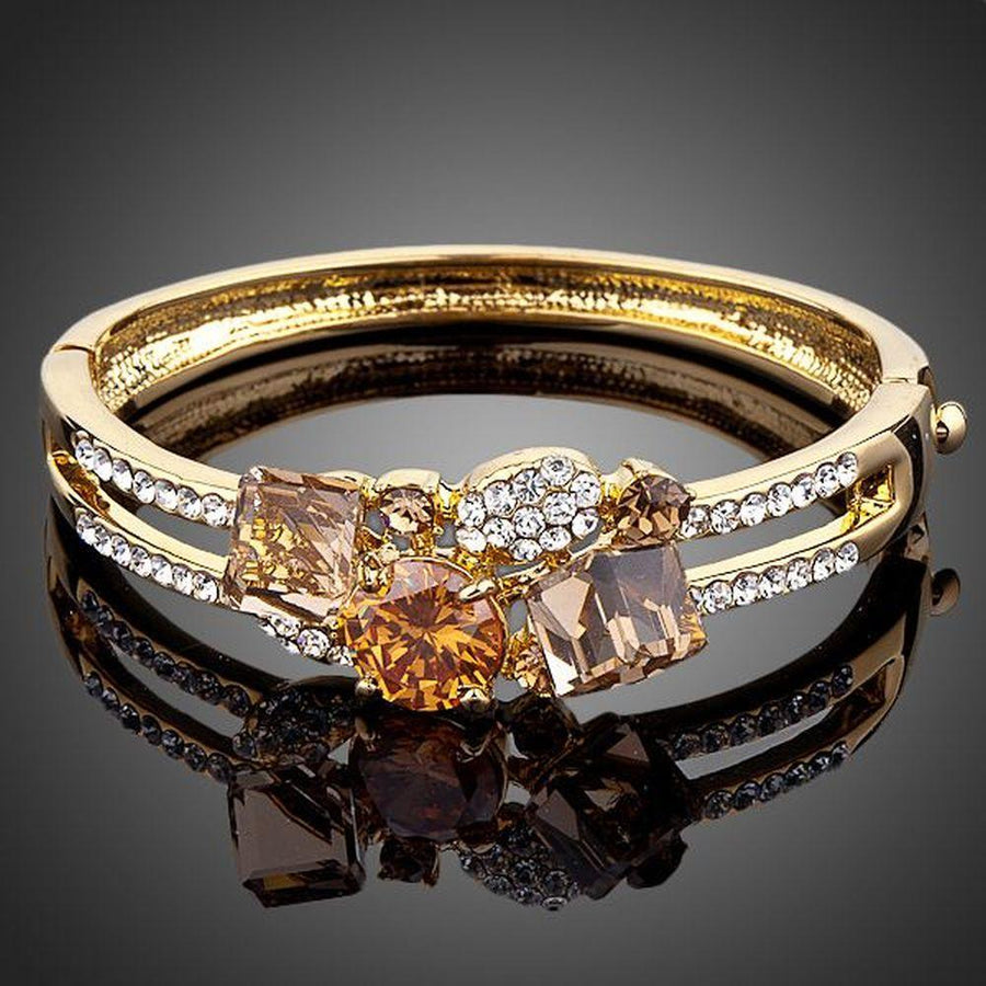 KHAISTA gold plated caramel crystal bangle on white background