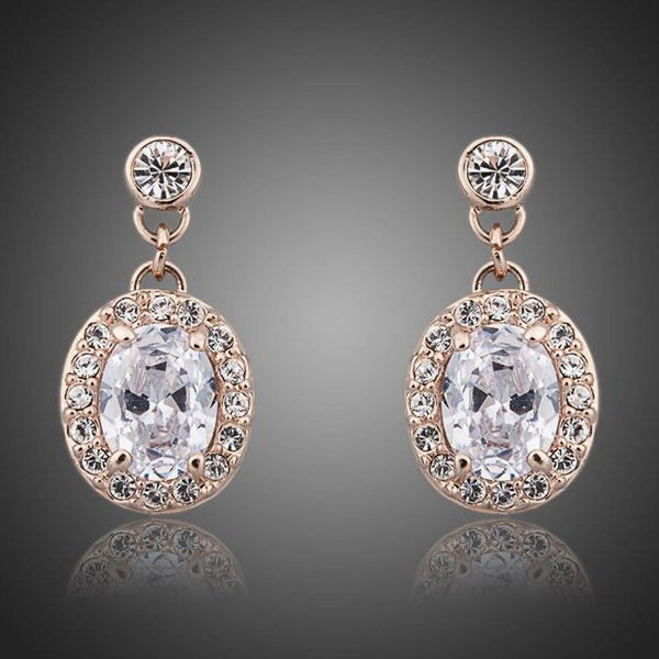 KHAISTA gold plated prolate crystal drop earrings on white background