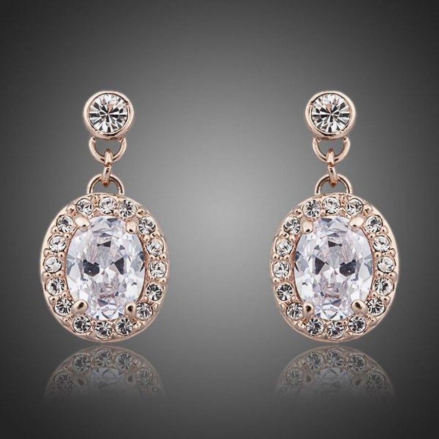 KHAISTA gold plated prolate crystal drop earrings on white background