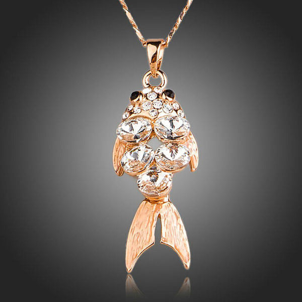KHAISTA gold crystal fish pendant necklace on white background