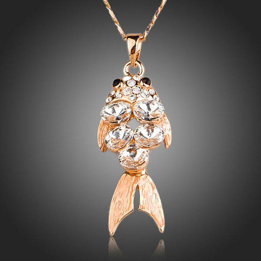 KHAISTA gold crystal fish pendant necklace on white background