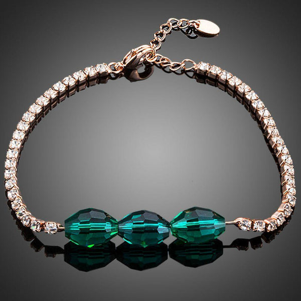 KHAISTA green crystal link chain bracelet on white background