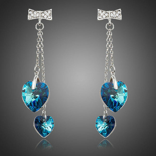 KHAISTA ocean blue crystal heart drop earrings on white background