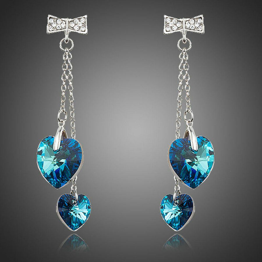 KHAISTA ocean blue crystal heart drop earrings on white background