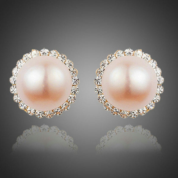 KHAISTA peach pearl dome stud earrings on white background