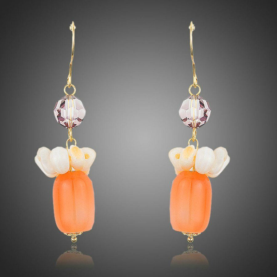 KHAISTA pumpkin orange crystal drop earrings on white background