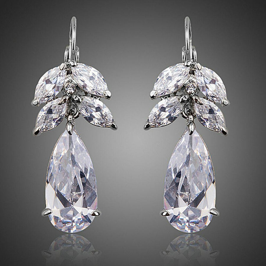 KHAISTA tree design CZ drop earrings on white background