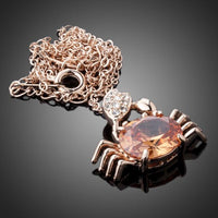 Side angle view of KHAISTA champagne crystal crab pendant necklace