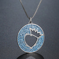 Close up detail of KHAISTA light blue crown heart necklace