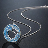 Side angle view of KHAISTA light blue crown heart necklace