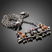 Side angle view of KHAISTA ancient sitting birds crystal necklace