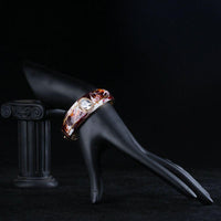 Side angle view of KHAISTA artistic oval crystal bangle