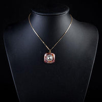 Side angle view of KHAISTA artistic squircle crystal pendant necklace
