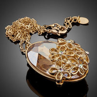 Close up detail of KHAISTA large oval champagne crystal flower necklace