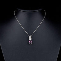 Side angle view of KHAISTA large purple crystal pendant necklace