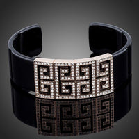 KHAISTA black G-shape crystal bangle on white background