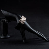 Side angle view of KHAISTA black G-shape crystal bangle