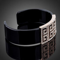Close up detail of KHAISTA black G-shape crystal bangle