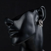 Close up of KHAISTA black leopard design clip earrings