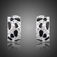 KHAISTA black leopard design clip earrings on white background