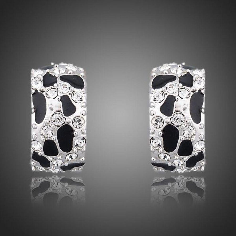KHAISTA black leopard design clip earrings on white background