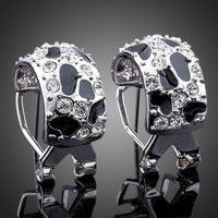 Side angle view of KHAISTA black leopard design clip earrings