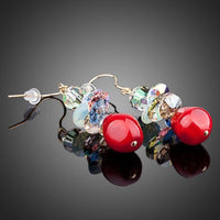 Close up of KHAISTA deep red crystal cluster drop earrings