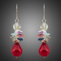 KHAISTA deep red crystal cluster drop earrings on white background