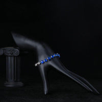 Side angle view of KHAISTA blue clear CZ bracelet