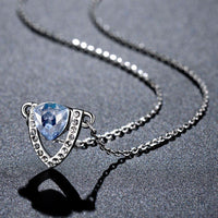Side angle view of KHAISTA blue Austrian crystal shield pendant necklace