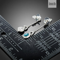Side angle view of KHAISTA blue Austrian crystal drop earrings