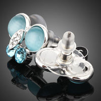Side angle view of KHAISTA blue butterfly stud earrings
