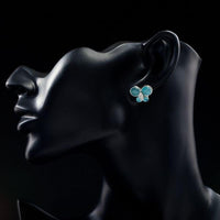 Close up of KHAISTA blue butterfly stud earrings