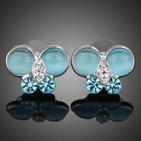 KHAISTA blue butterfly stud earrings on white background