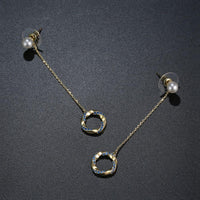 Close up of KHAISTA blue CZ pearl dangle earrings
