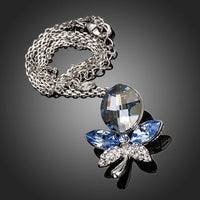 Side angle view of KHAISTA blue crystal dragonfly pendant necklace