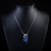 Side angle view of KHAISTA blue effect crystal cluster necklace