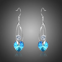 KHAISTA blue heart crystal drop earrings on white background