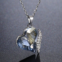 KHAISTA blue crystal heart dangle pendant necklace on white background