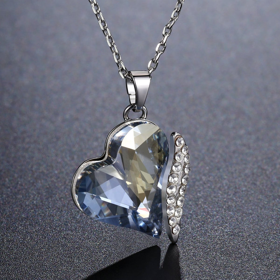 KHAISTA blue crystal heart dangle pendant necklace on white background
