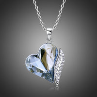 Side angle view of KHAISTA blue crystal heart dangle pendant necklace
