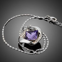 Side angle view of KHAISTA blue crystal love pendant necklace